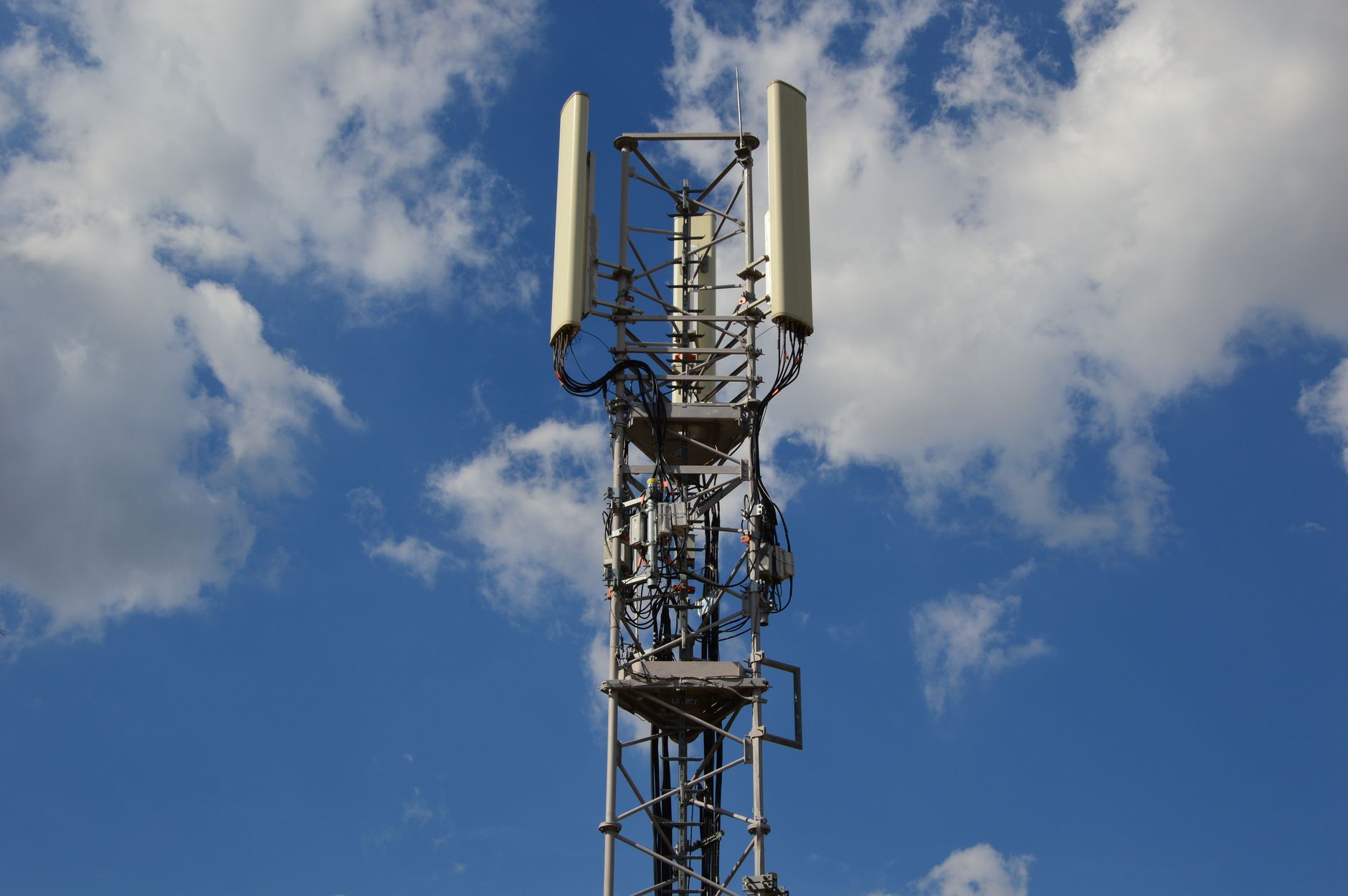 Wieża 5G na tle błękitnego nieba symbolizująca nowoczesną łączność