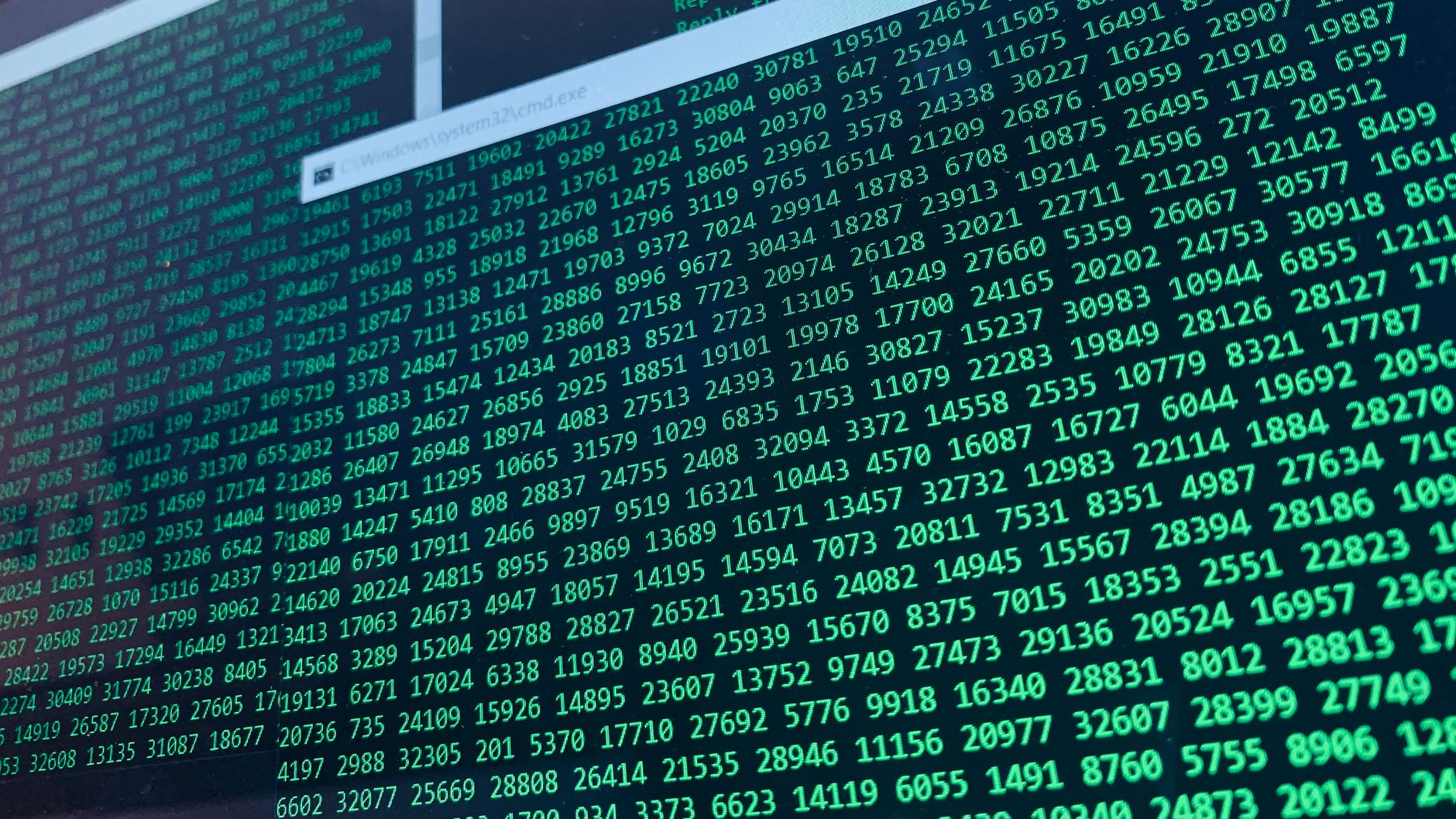Zielony kod binarny na ekranie komputera symbolizujący atak w chmurze