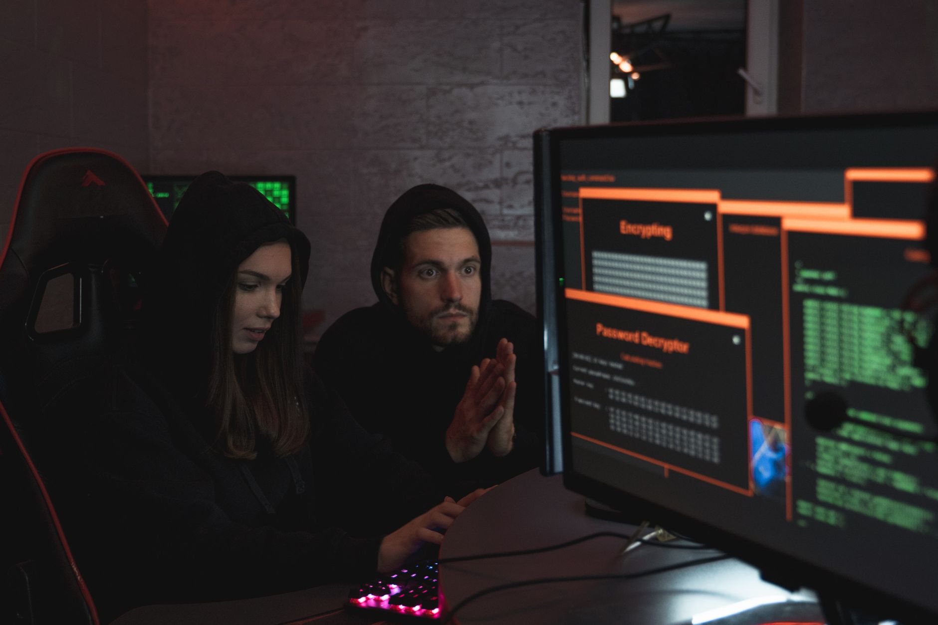 Eksperci cyberbezpieczeństwa w bluzach analizują szyfrowane dane na monitorach