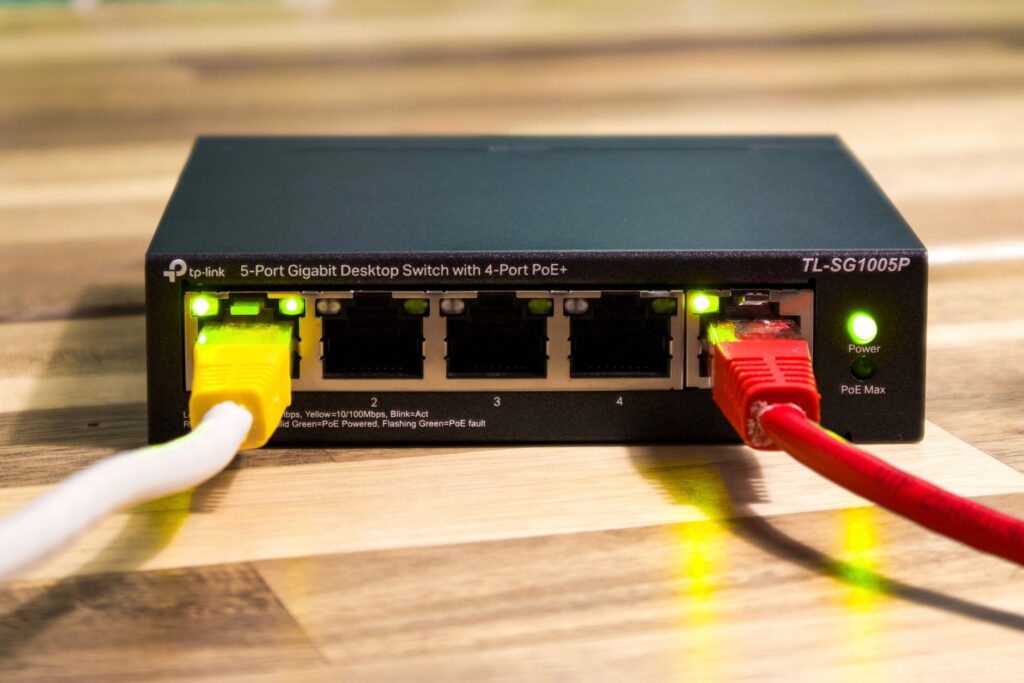Switch Ethernet TP-Link z podłączonymi kolorowymi kablami sieciowymi