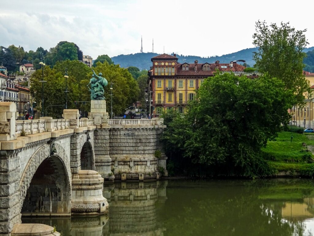 Zabytkowy most i zabudowa Turynu nad spokojną rzek